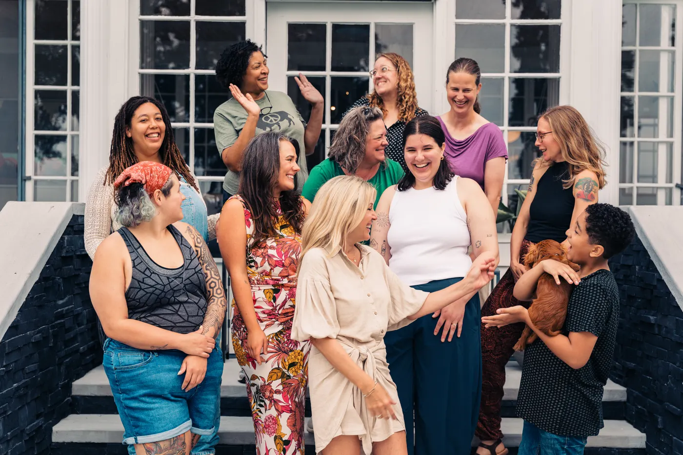 DoulaBrella doulas laughing together on the steps of the training house
